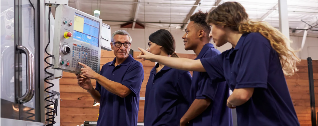 A group of machinists looking at controls